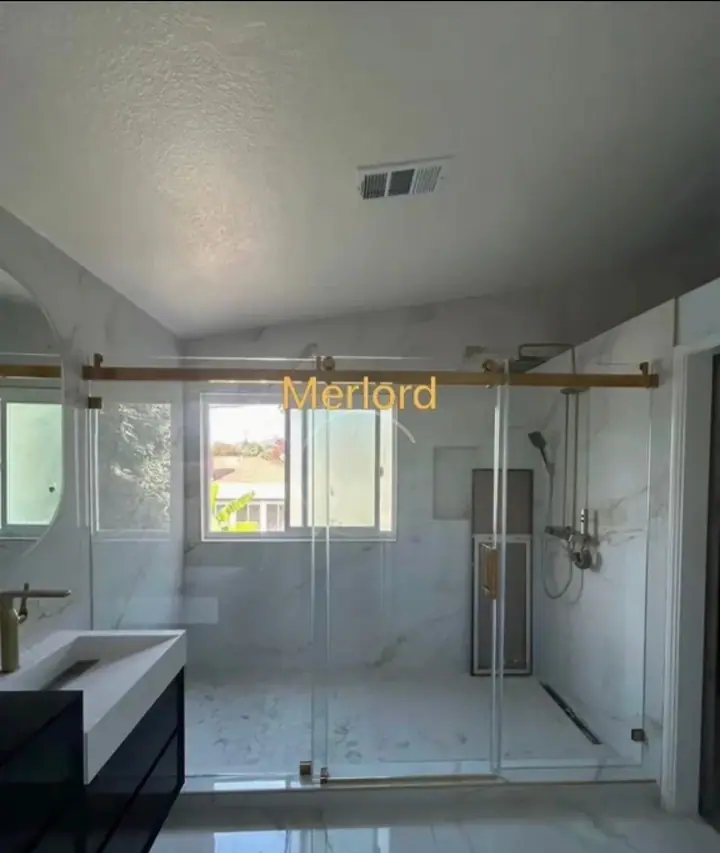 Sliding door with brushed gold hardware installed by Merlord