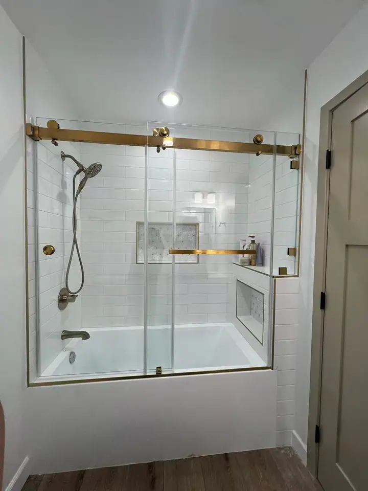 Bathtub sliding door in brushed gold installed by Merlord