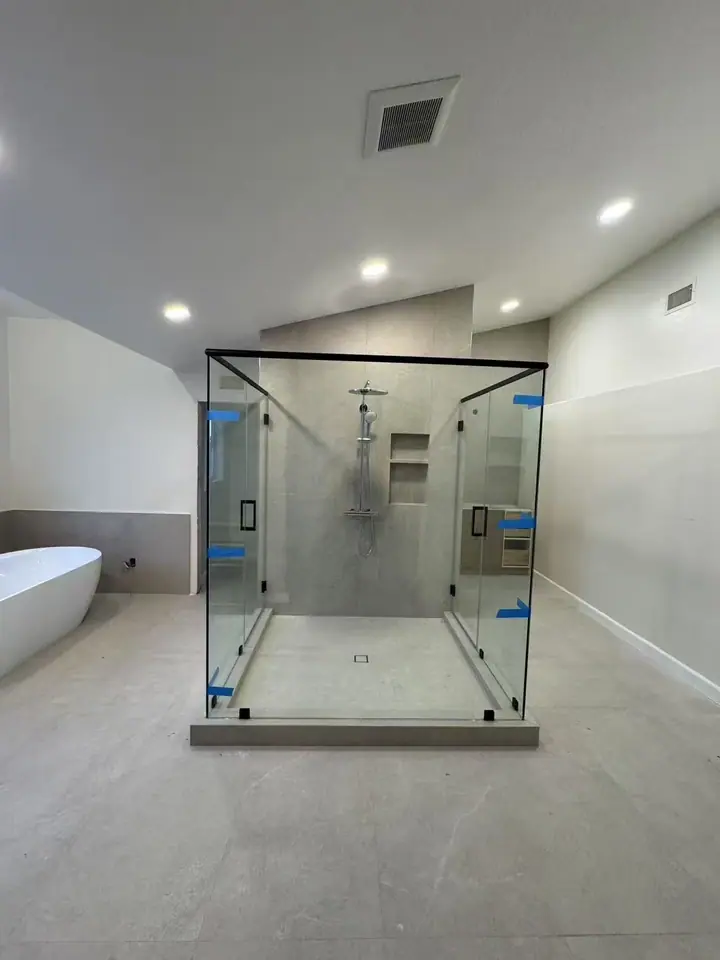 Freestanding glass enclosure with black trim installed by Merlord