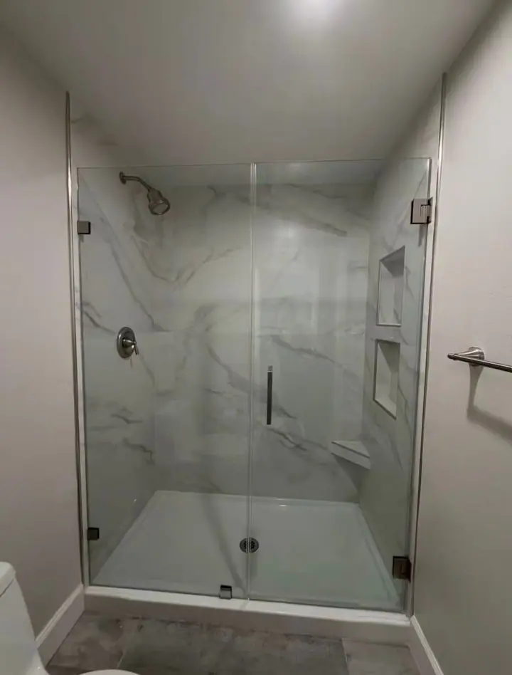 Frameless hinged shower door installed by Merlord