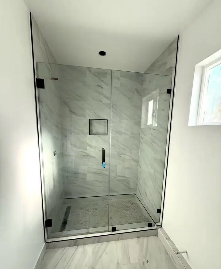 Frameless hinged shower door installed by Merlord
