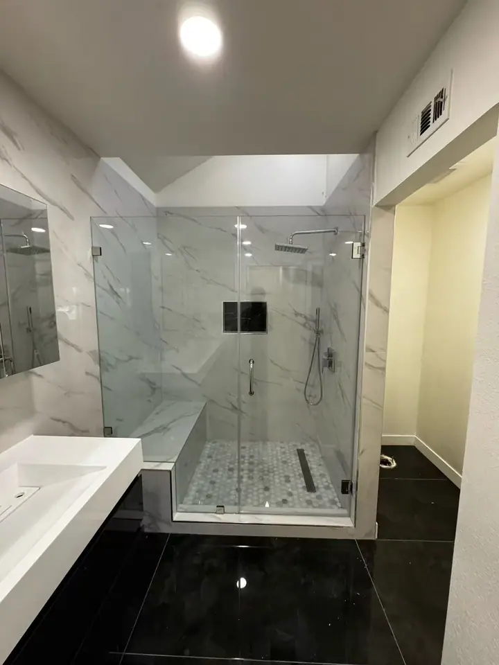Frameless hinged shower door installed by Merlord